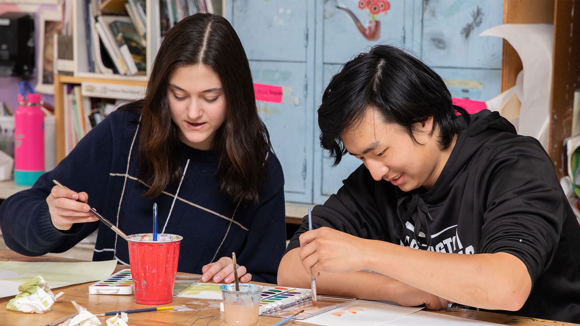 Two Farmington high school students showing their creativity in art class.