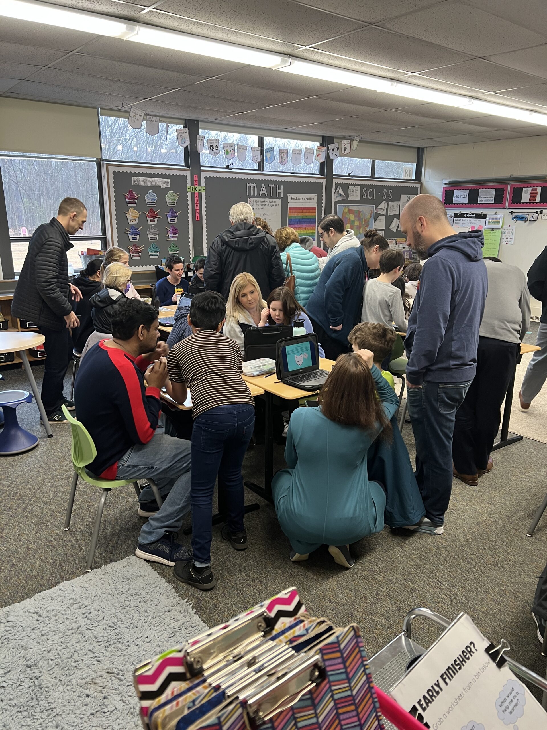 children and parents gathered around desk