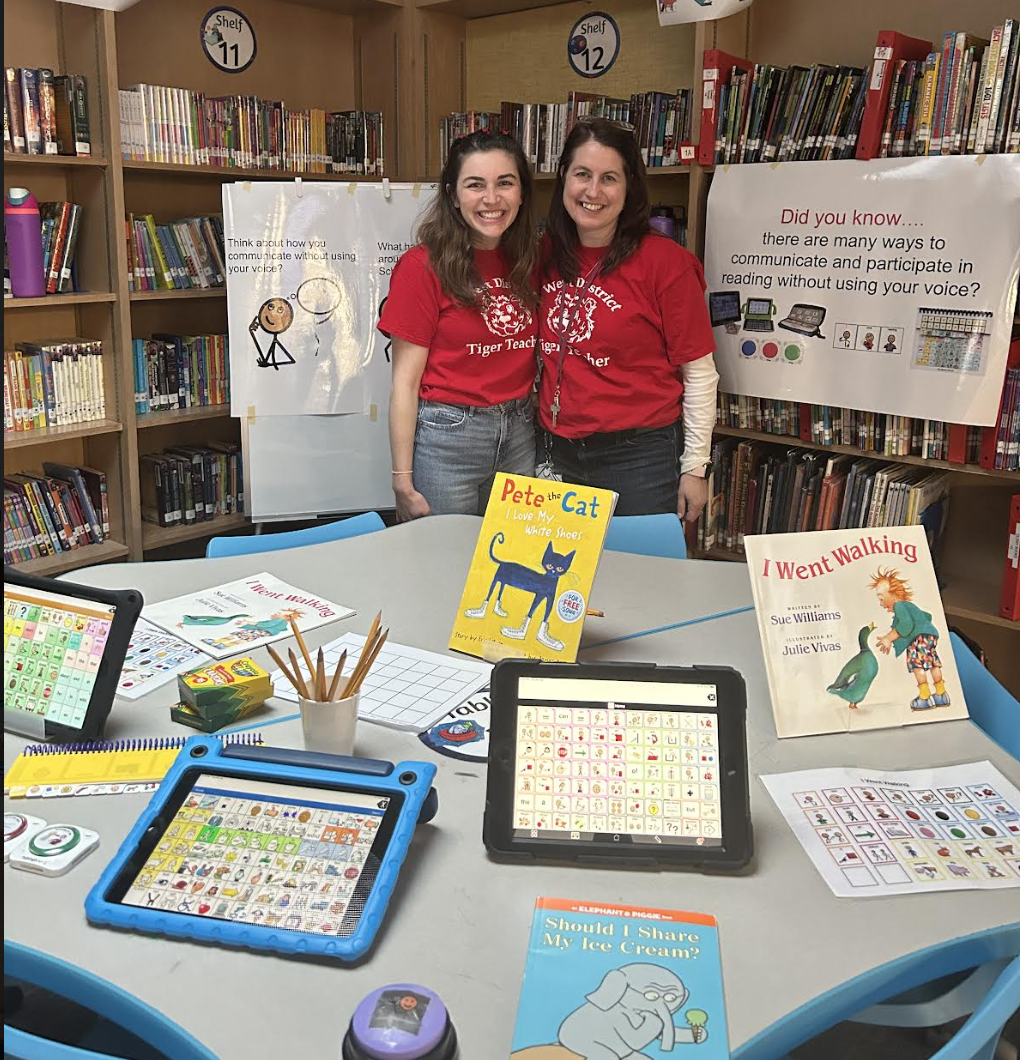 teachers standing near display of assistive technology tools